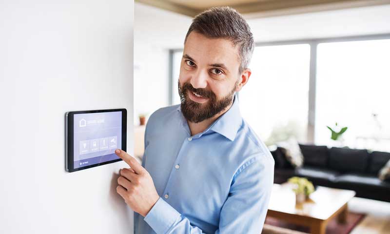 Zufriedener Kunde vor Smart Home-Steuerung im Wohnzimmer